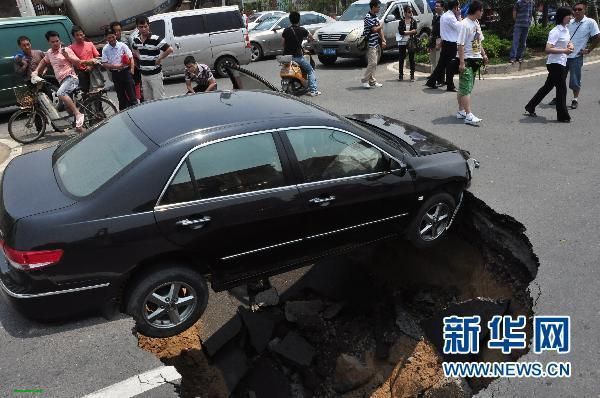 6月4日，一辆本田轿车在南昌街头卡在塌陷路面上动弹不得。当日，南昌市昌南大道与迎宾北大道交叉口附近路面 ...
